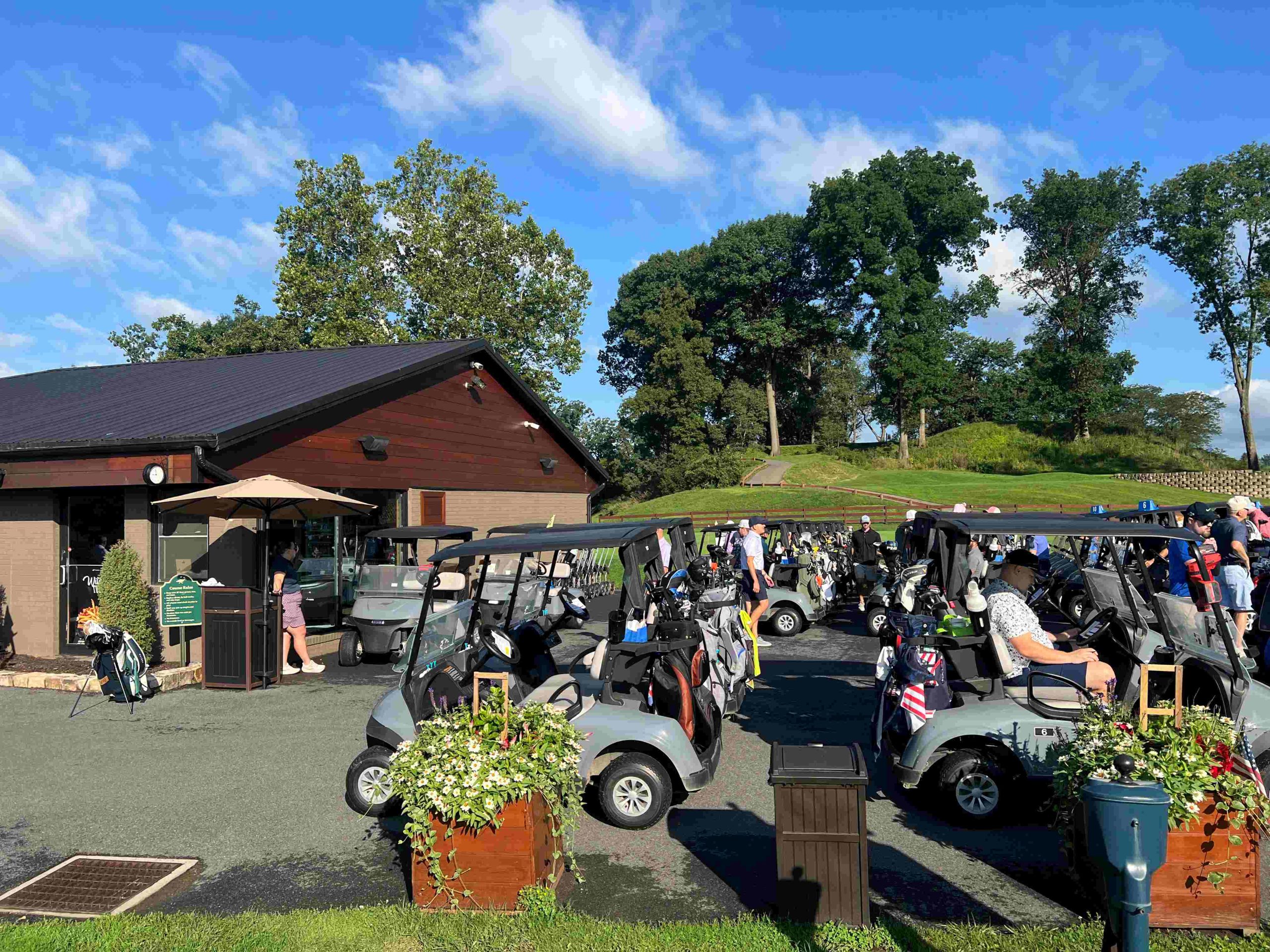 A golf course driveway with golf carts